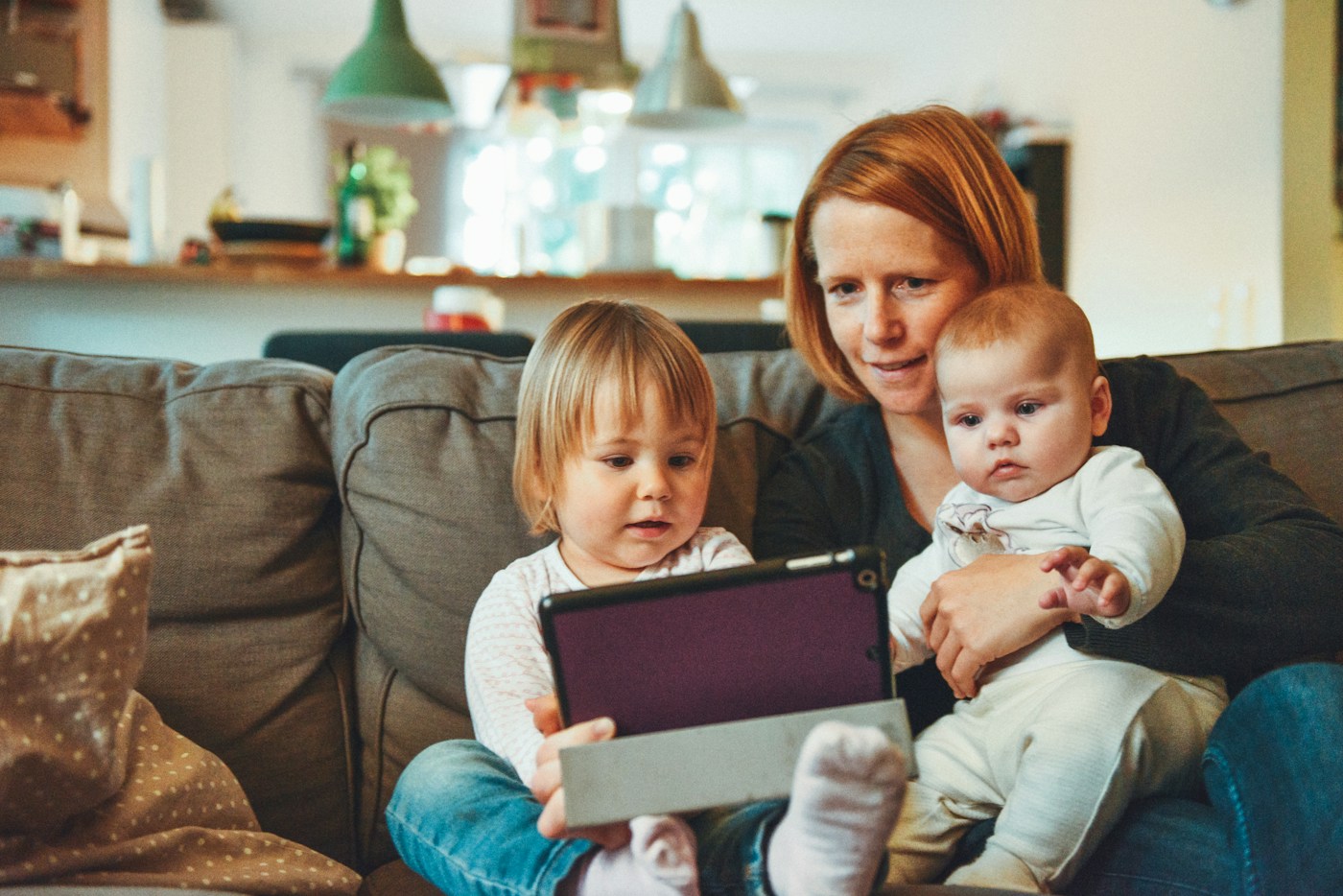 A mother and her two children at home with a tablet